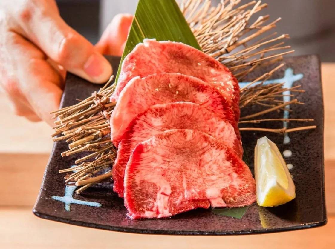 レモンと枝を添えた皿に盛られた霜降り和牛の薄切り